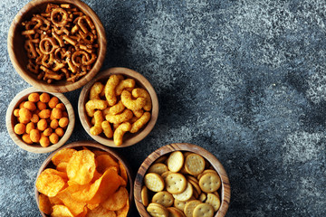 Salty snacks. Pretzels, chips, crackers in wooden bowls.