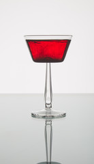 red drink with ink in a martini glass