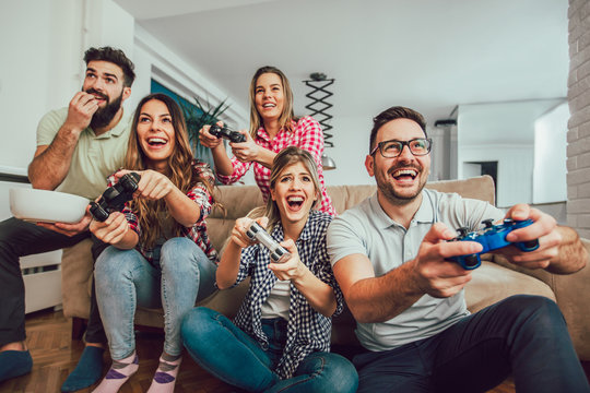 Group Of Friends Play Video Games Together At Home, Having Fun.