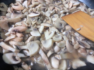 Sliced mushrooms are fried in a frying pan, mushrooms in a frying pan, mushrooms are prepared in the home kitchen, retro style, American cuisine, vegetarian food