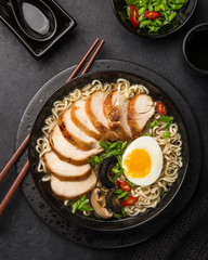japanese ramen noodle with chicken, shiitake mushroms and egg in black bowl,