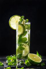 Mojito cocktail with  lime and mint on black background, selective focus