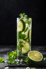 Mojito cocktail with  lime and mint on black background, selective focus