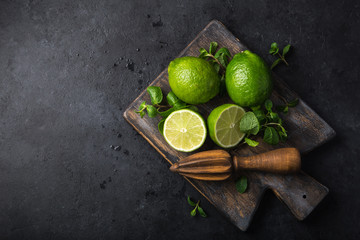 fresh green lime and mint on wooden cutting board