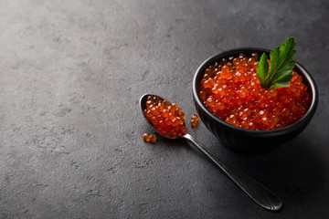 delicious red caviar in black bowl