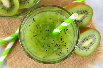 Sliced kiwi and smoothie slices in a glass on a gray table. Healthy food.