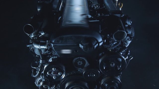 Technological Epic Background of the Dark Chamber with Smoke and Metal Engine Hang on the Steel Chains in Center of Composition. The modern concept of the industrial mechanism with the present urban