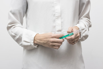 woman in white shirt with syringe in her hands