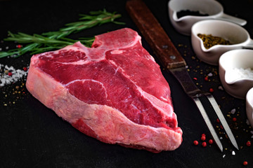 raw porterhouse steak on a dark wood