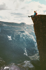 Man tourist sitting on Preikestolen cliff edge in Norway mountains Travel Lifestyle adventure...