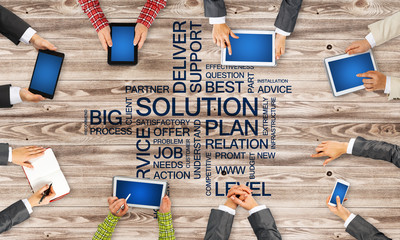 Top view of businesspeople sitting at table and using gadgets