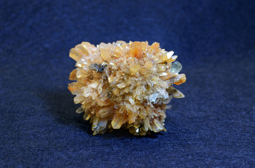 Clouse-up of yellow creedite mineral from Kazakhstan on blue background