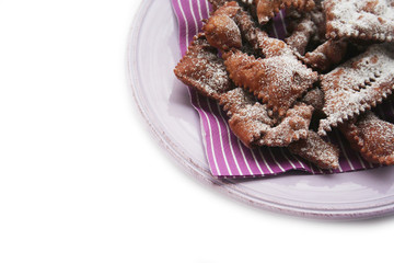 Italian carnival pastry on a plate on white. Traditional carnival chocolate crostoli 