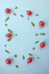Blue background with green leaves and cherry tomatoes