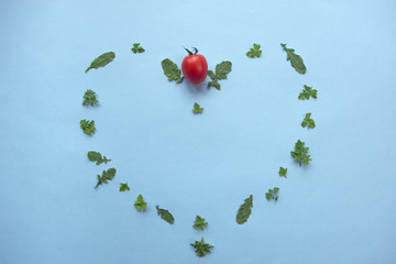 Leaf of green parsley and rucola in heart shape and cherry tomato