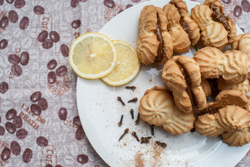Fototapeta na wymiar cookies on a plate with condensed milk with lemons under a coffee