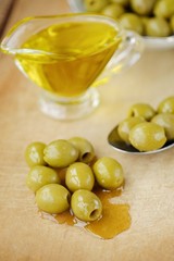 Delicious green olives and oil on the table  