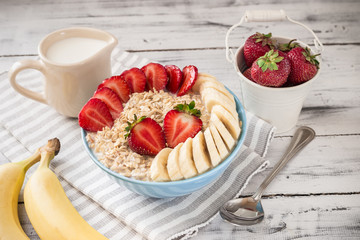 Oatmeal in bowl with strawberries and bananas