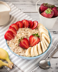 Oatmeal in bowl with strawberries and bananas