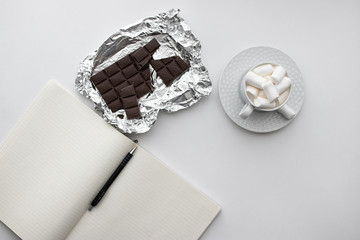 top view on white background notebook, Notepad with pen, Cup of drink and marshmallows, chocolate