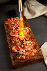 bruschetta with delicious fish on a cream cushion with capers and olive oil