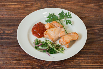 Roasted chicken breast fillet on a plate. Appetizing dish on the wooden brown table.