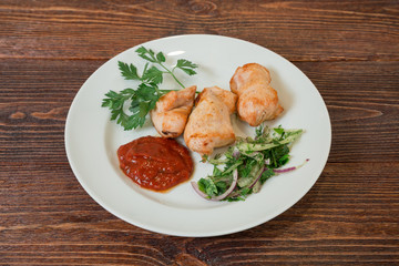 Roasted chicken breast fillet on a plate. Appetizing dish on the wooden brown table.