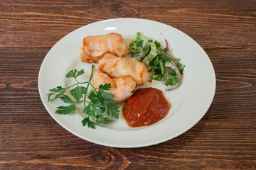 Roasted chicken breast fillet on a plate. Appetizing dish on the wooden brown table.