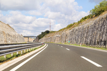 Scenic view on highway road leading through in Istria, Croatia, Europe / Beautiful natural environment, sky and clouds in background / Transport and traffic infrastructure / Road signs and signaling.