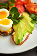 Bruschetta, assorted, different fillings, on plates with a soft-boiled egg in the middle