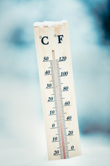 Wooden thermometer in the snow. Four degrees Celsius on the plus after snowfall.