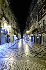 Fototapeta na wymiar Coimbra, Portugal, August 13, 2018: Night view of the main shopping street in the old center of the city with people walking and very well lit