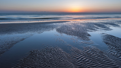Sunrise with low clouds on Omaha Beach Normandy France