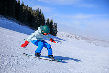one young woman snowboarding in winter mountains