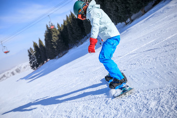 Fototapeta na wymiar one young woman snowboarding in winter mountains