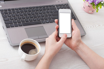 A woman holds smartphone white phone in the workplace in the roo