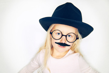 Little girl in hat with fake moustache