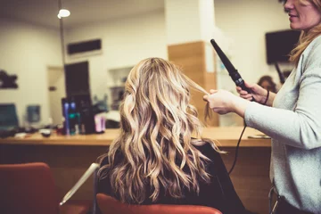 Foto op Plexiglas Kapsalon Beautiful hairstyle of young woman after dying hair and making highlights in hair salon. 