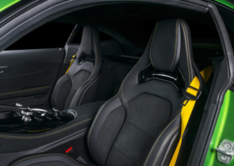 Modern Luxury sport car inside. Interior of prestige car. Leather seats with yellow stitching. Black perforated leather. Modern car interior details. Automatic gear stick shift. Media Buttons