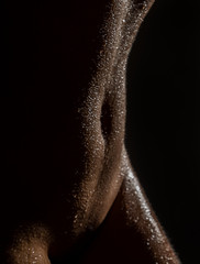 sexy nude female body with water drops on a black background