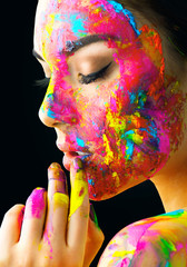 Beauty model girl with colorful paint on her face. Portrait of beautiful woman with flowing liquid...