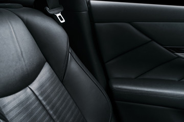 Modern luxury car black perforated leather interior. Part of leather car seat details. Modern car interior details