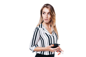 Fototapeta premium beautiful girl make-up artist with beautiful hair in a striped shirt on a white background in whose hands tassels and other makeup accessories