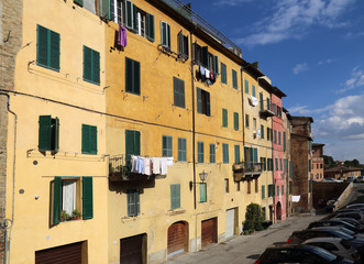 Fototapeta na wymiar Laundry hangs from windows in Siena, Italy