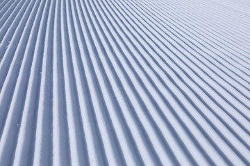 Diagonal track lines on a ski slope left by a snowcat
