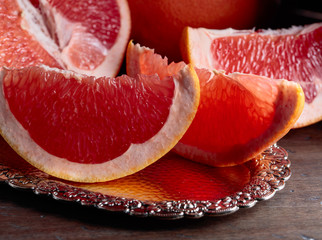 Slices of fresh ripe grapefruit on wooden table.