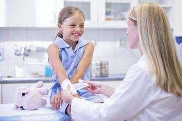 Girl having bandage applied to arm