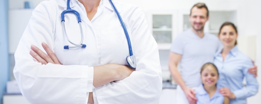 Mid section of doctor with family in background