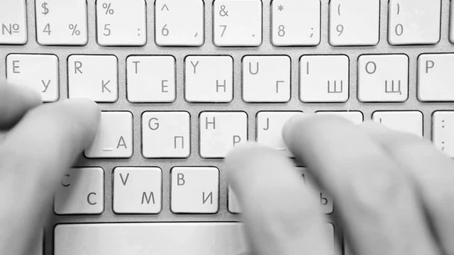 Black and white footage of a person tyoing on the bilingual keyboard