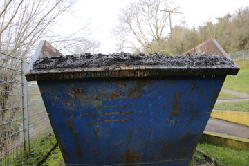 Abfallcontainer der mit klärschlamm gefüllt ist. Der container ist übervoll, der schlamm könnte...